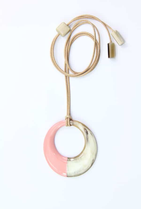 Collier Sautoir avec motif rond en corne beige-blanc et laque rose. Environ 7,5 cm de diamètre monté sur un cordon beige ajustable en longueur jusqu’à 110 cm. Orligne Genève SBP186 SOY-1-1